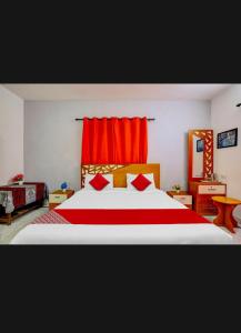 a bedroom with a large bed with red curtains at HILL BIRD HERITAGE HOME Stay in Ooty