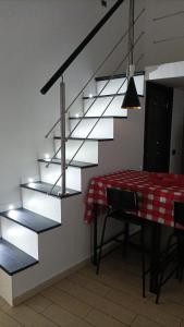 une salle à manger avec une table et un escalier en métal dans l'établissement Suite in città, à Naples