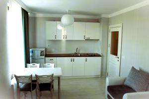 een keuken met een tafel en stoelen en een wastafel bij Private apartments Stamopolu lux in Primorsko