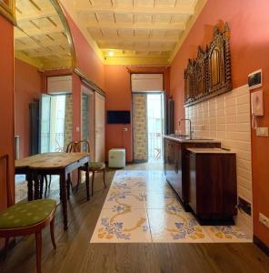 - une cuisine aux murs orange avec une table et des chaises dans l'établissement La Canonica, à Turin