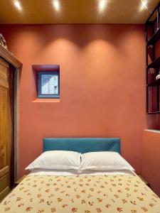 - une chambre avec un mur orange et un lit dans l'établissement La Canonica, à Turin