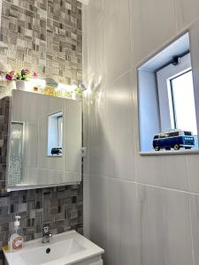 un bagno con lavandino e specchio e un pulmino alla finestra di Casa da Joana a Portimão Altre 17 foto