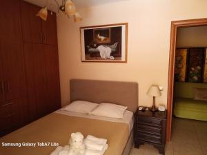 a bedroom with a bed with a white dog sitting on it at VILLA AVATOS 3 - Near to the port of Rafina and the airport of Athens in Áyios Spirídhon +10 photos