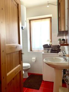 a bathroom with a sink and a toilet and a window at Cima de' Piazzi Apartment 2 in Isolaccia