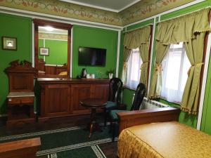 a bedroom with green walls and a desk and a bed at Family Hotel at Renaissance Square in Plovdiv