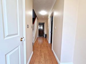 a hallway with a white door and wooden floors at The Forest House in Brandon