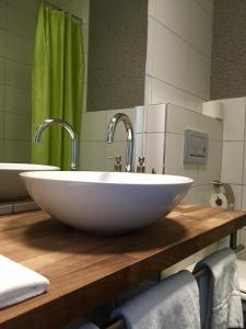 a bathroom with a white sink with two faucets at Hotel AM Schloss in Thun