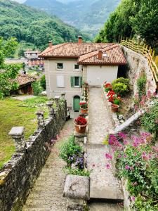 a house on a hill with flowers in front of it at La Casa sulla collina del Castello in Breno