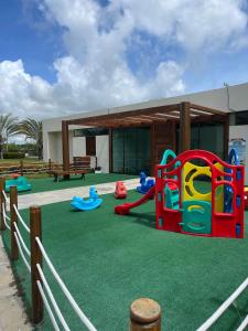 a playground with play equipment on a lawn at Flat Luxo Praia dos Carneiros in Praia dos Carneiros