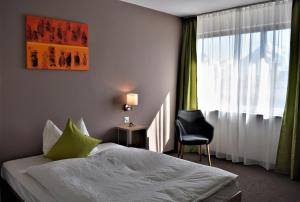 a hotel room with a bed and a chair and a window at Hotel AM Schloss in Thun +19 photos