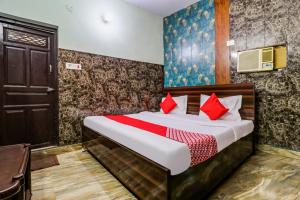 sypialnia z łóżkiem z czerwonymi poduszkami w obiekcie OYO Flagship 84929 Omax Guest House w mieście Faridabad
