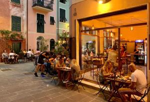 a group of people sitting at tables outside a restaurant at Casa Liguria - luxuriöses Ferienhaus - 5 Gehminuten zum Strand - zwischen Portofino, Sestri Levante, Cinque Terre! in Cavi di Lavagna