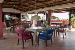 a dining room with tables and chairs on a patio at Mama Africa Art Residence & Art Center Gambia in Tanji