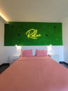 a bedroom with a large bed with a green wall at THEASIS 4 luxury studio with sea view in Neos Marmaras
