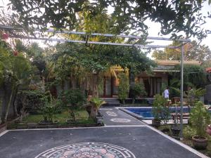 a garden with a pergola and a swimming pool at Villa Indah Anugrah in Kubu