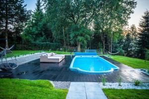 a swimming pool in a yard with a couch and a chair at The View in Iława