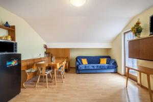 uma cozinha e uma sala de estar com um sofá azul em Oberkapillhof em Meltina