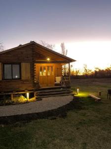 a log cabin with lights in front of it at Cabañas El Sosiego in Azul