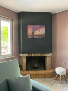 a living room with a fireplace with a picture of the eiffel tower at Seaside Blue Coast Apartment in Anavissos