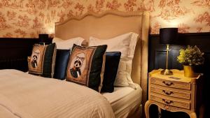 a bedroom with a bed with pillows and a night stand at Atypique Le Domaine de la Roche Bernard 
