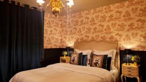 a bedroom with a bed and a chandelier at Le Domaine de la Roche Bernard Jacuzzi, piscine & Sauna 