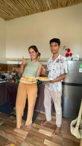un hombre y una mujer sosteniendo un plato de pizza en Rangsot Inn en Pawenang