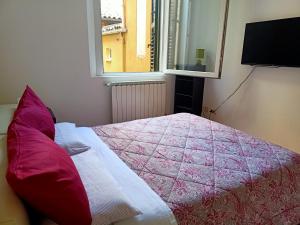 1 dormitorio con 1 cama con manta rosa y ventana en Masc 26, en Bolonia