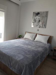 een slaapkamer met een bed met een blauw en wit dekbed bij AniBo studios and apartments ZERO POINT 46 in Thessaloniki