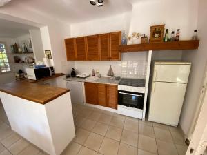 een keuken met een witte koelkast en een fornuis bij Maison climatisée, 3 chambres, 2 étoiles, tout confort in Noves