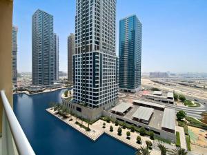 uitzicht op een stad met hoge gebouwen en water bij StoneTree - Amazing 1BR with Lake View in Dubai