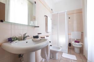 アルバにあるレジデンス XX セッテンブレの白いバスルーム(洗面台、トイレ付)