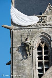 a soldier hanging from the side of a tower at gite de La place de l'église in Sainte-Mère-Église