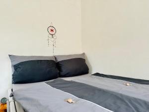 uma cama com duas almofadas e um relógio na parede em ☆Gemütliche 1-Zimmerwohnung mit Terrasse☆ 