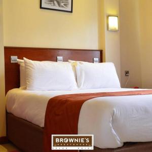 a hotel room with a bed with white pillows at Brownies Deluxe in Nakuru