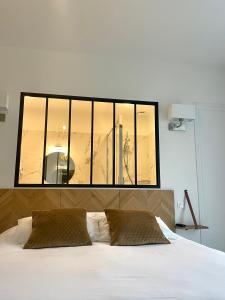 a bedroom with a large window above a bed at LA TOUR AUX CRABES près de la plage in Dieppe