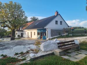 ein weißes Haus mit einer Bank davor in der Unterkunft Čenovický dvůr in Čestín