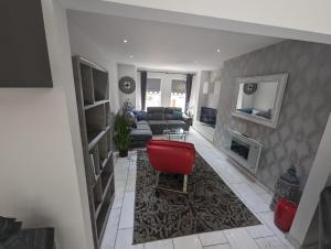 a living room with a red chair and a couch at House in belfast in Belfast