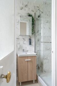 y baño con lavabo y ducha. en Cozy & modern flat next to M12 Front Populaire en Saint-Denis