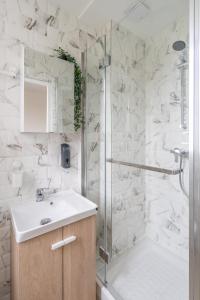 a bathroom with a sink and a shower at Cozy & modern flat next to M12 Front Populaire in Saint-Denis