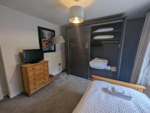 1 dormitorio con 1 cama, TV y vestidor en House in belfast, en Belfast