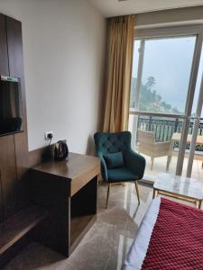 een hotelkamer met een televisie en een stoel bij LUXE RESORTS - CENTRALLY HEATED AIR CONDITIONED HOTEL in THE HEART OF KASAULI in Kasauli
