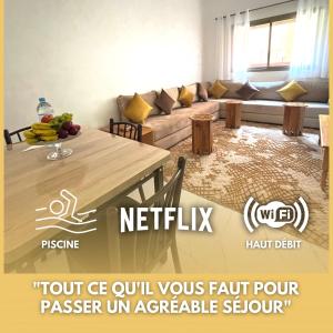 ein Wohnzimmer mit einem Tisch und einem Sofa in der Unterkunft ASAMA appartement avec piscine in Marrakesch