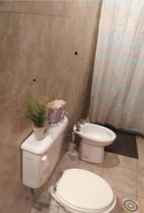 un baño con aseo y un inodoro con flores. en Dotzawer home en Villa General Belgrano