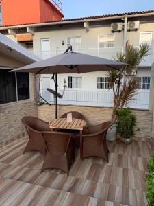 a table and chairs with an umbrella on a patio at Pousada Dragao Do Mar in Fortaleza