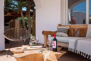 a patio with a bed and a table with a bottle of wine at Private Villa near Ibiza town (10min) in Sant Josep de Sa Talaia