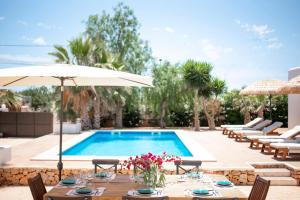 a pool with tables and chairs and an umbrella at Private Villa near Ibiza town (10min) in Sant Josep de Sa Talaia