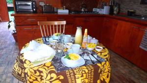 a table with a yellow and white table cloth with food on it at Hostal Makohe Rapa Nui in Hanga Roa