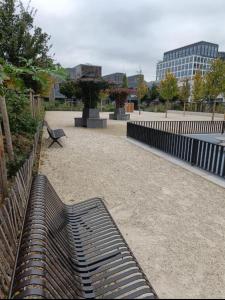 a bench in a park with buildings in the background at BeautifulParis18 in Paris