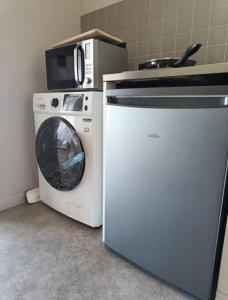 a washing machine and a microwave in a kitchen at BeautifulParis18 in Paris