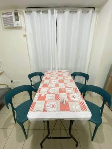 a table with four chairs and a table cloth on it at Blessed Condo for 6 - include net, water & electric in Manila